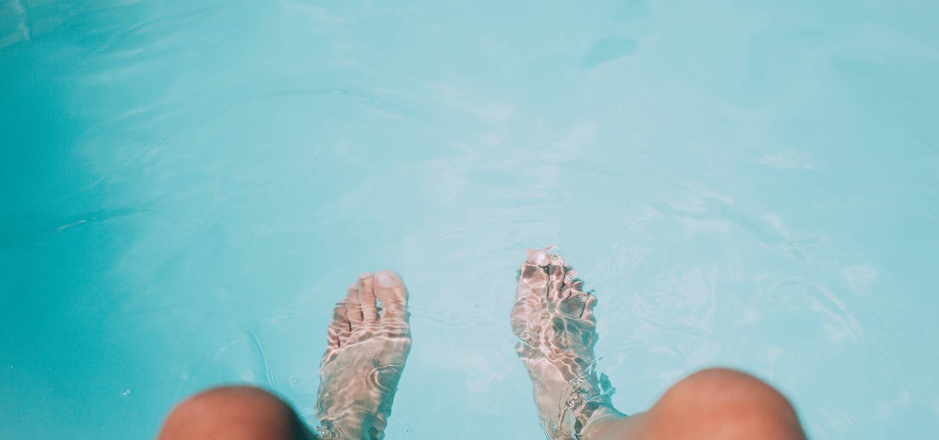 Beine baumeln im Pool
