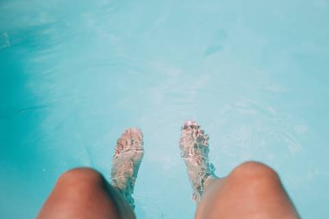 Beine baumeln im Pool
